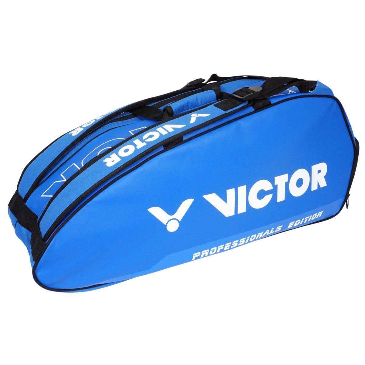 The Victor Multithermo 9031 Badminton Bag in blue is designed with multiple compartments, including a handy shoe section for equipment transport. It prominently displays the white Victor logo and text, making it perfect for badminton or other racket sports.