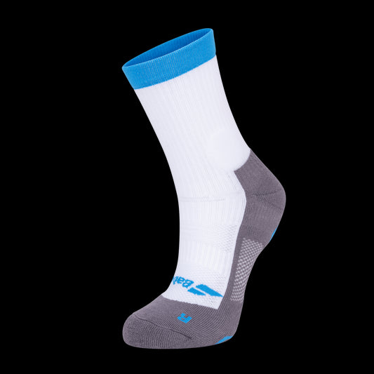 The Babolat Pro 360 Men's Badminton Sock in White and Diva Blue is showcased on a black background, featuring a blue cuff, white upper, and gray heel and toe. This athletic sock includes reinforced areas for enhanced support, Fiberdry technology for moisture management, and environmental graphics on the toe.