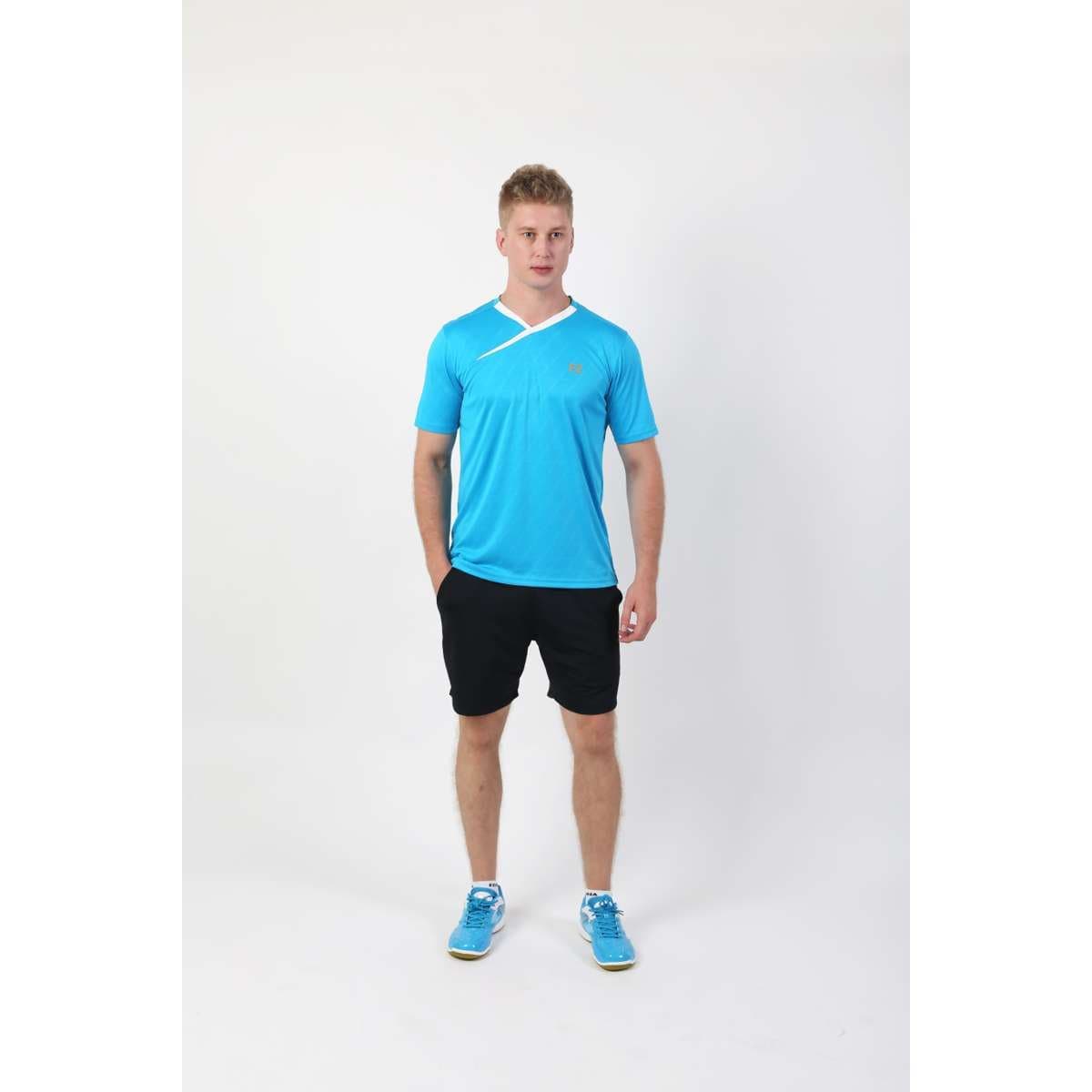 A person stands against a plain white background wearing the FZ Forza Byron Blue Badminton T-Shirt with a smart neckline, paired with black shorts and matching blue athletic shoes. Crafted from lightweight material, they face forward with a neutral expression and hands at their sides.