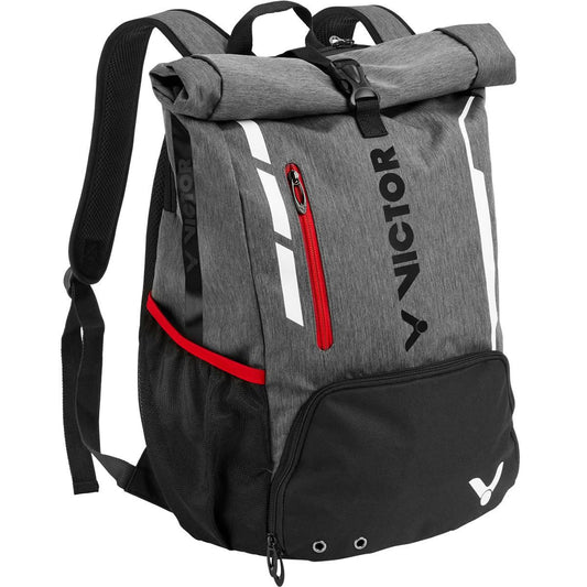 Presenting the Victor Badminton Rucksack 9109, a versatile backpack in gray with black detailing. It features a roll-top closure, a front zip pocket accented in red, mesh side pockets, and adjustable shoulder straps for maximum comfort. The brand name "Victor" is prominently displayed on the front in black.