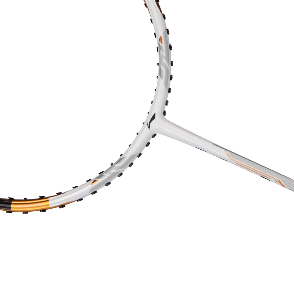 A close-up of the Li-Ning TecTonic 7 4U badminton racket emphasizes the curve of the frame and strings, made from T1100G military-grade carbon fiber. The racket features a sleek design with a predominantly white color, orange accents, and black string grommets.